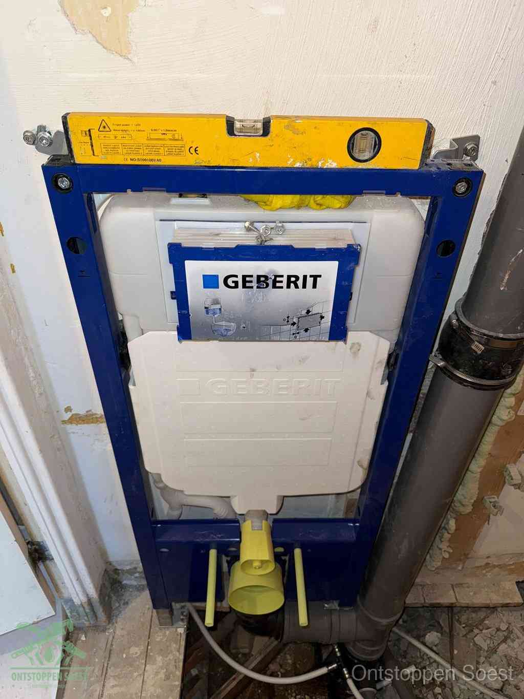 Een Geberit inbouwreservoir met frame voor een hangtoilet tegen de wand, met de afvoerbocht naar de vloer, kenmerkend voor een verstopt hangtoilet in Soest
