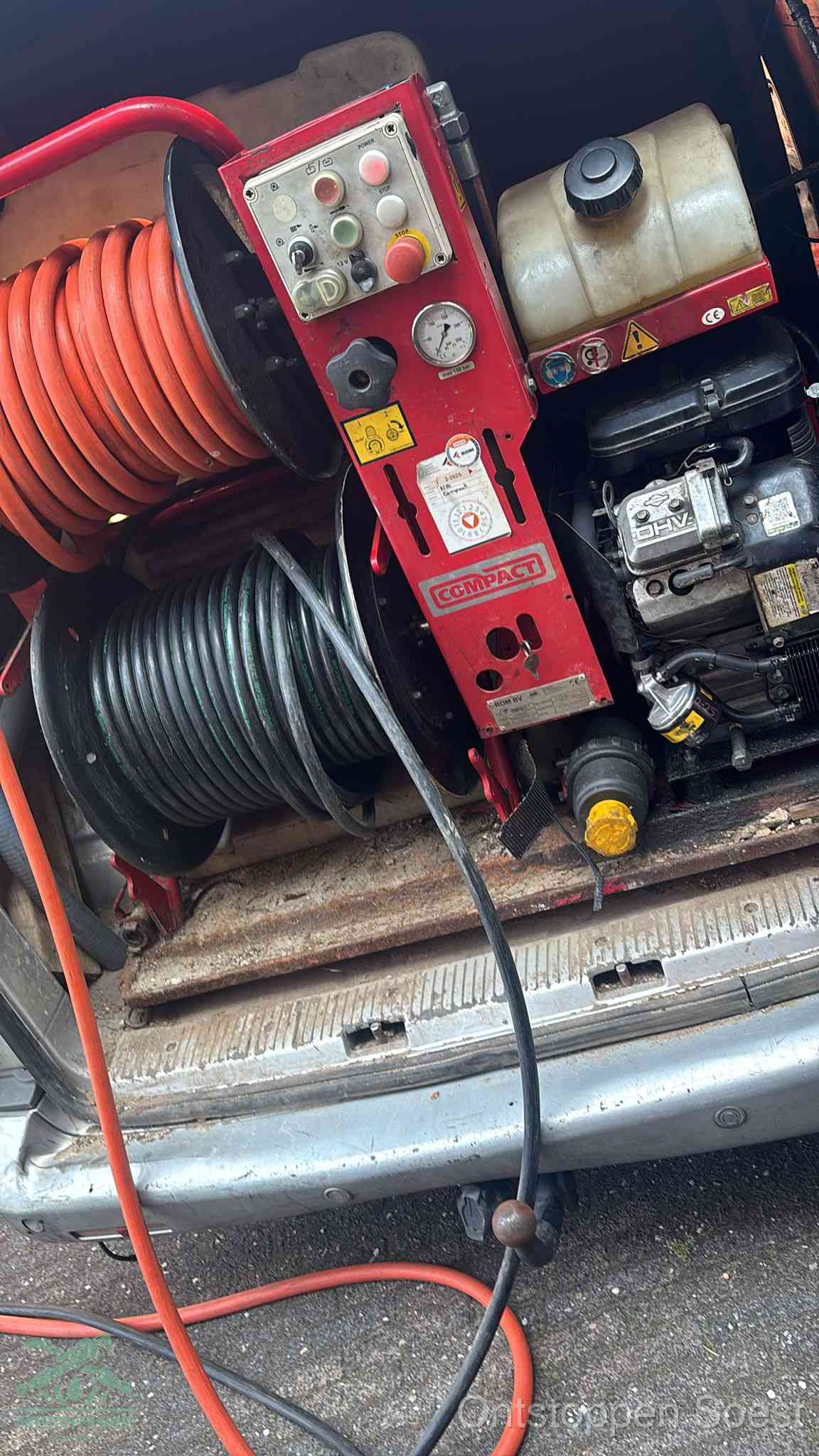 Een rood hogedruk-rioolreinigingstoestel in de laadbak van de bedrijfsbus, apparatuur voor een hardnekkige afvoerverstopping in Soest
